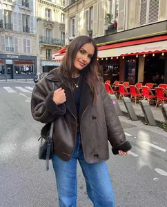 Stylish brown faux shearling jacket with wide lapel collar in a European street setting