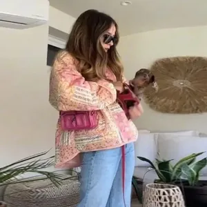 Bohemian style pink floral quilted jacket worn by a model in a cozy indoor setting