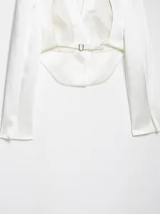 Dettaglio che mostra la lussuosa trama in raso bianco di questa giacca blazer corta.