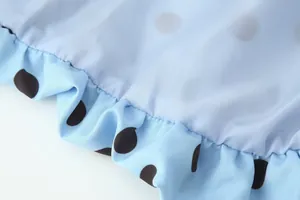 Nahaufnahme von hellblauem Polka-Dot-Stoff mit einer eleganten Rüschenkantenstruktur