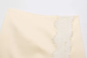Close-up of cream lace spliced skirt showing intricate eyelash lace detail and fabric texture.