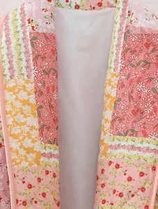 Detailed macro view of the quilted floral patchwork pattern on a pink lapel jacket