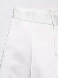 Dettaglio ravvicinato della vita e delle cuciture delle tasche dei pantaloni in raso bianco