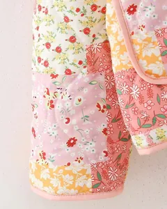 Macro close-up detail of a quilted floral patchwork jacket with vibrant patterns.