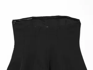 Detailed view of the side invisible zipper and vertical seams on a black strapless tube top.