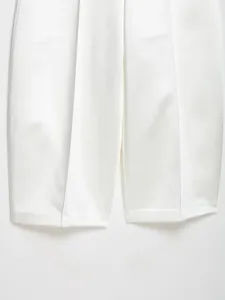 Dettaglio dei pantaloni a gamba larga in raso bianco con trama del tessuto
