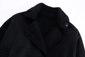 Close-up of the black shearling collar and suede texture of a women's jacket