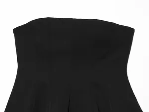 Close-up detail showing the structured paneling of the black strapless tube top.