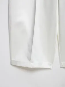 Primo piano dei pantaloni a gamba larga in raso di seta bianco perla con dettagli
