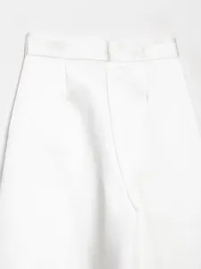 Dettaglio dei pantaloni a gamba larga in raso bianco a vita alta che mostra il taglio e il tessuto.