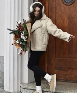 Close-up of model wearing beige shearling jacket and fleece-lined platform slippers