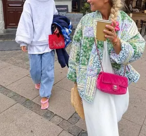 Street style shot of a women's colorful quilted floral print jacket in outdoor setting