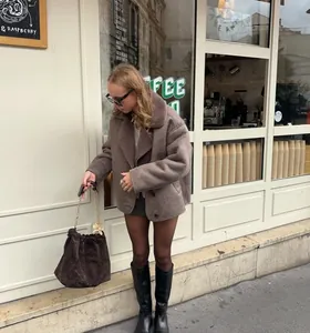 Stylish brown lamb wool collar jacket with oversized fit on a woman in a street setting.
