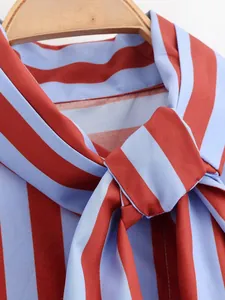 Vista detallada de la camisa de rayas rojas y azules con elegante lazo en el cuello