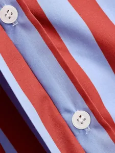 Detalle de cerca de una camisa a rayas rojas y azules que muestra el tejido y botones