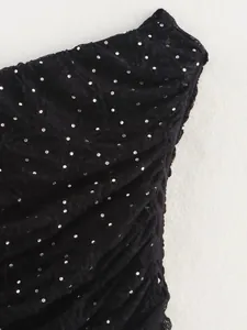 Macro detail showing the black textured fabric with sparkling silver sequins and ruffles.