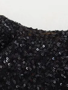 Detailaufnahme der glänzenden schwarzen Pailletten am eleganten ärmellosen Kleid