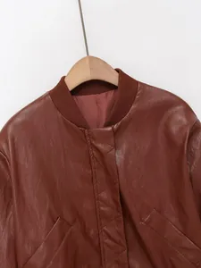 Gros plan détaillé du col et de la face avant surpiquée de cette veste en similicuir marron.