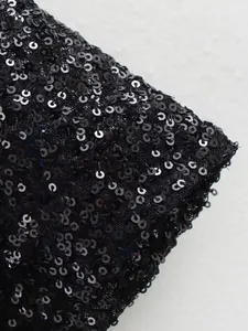 Nahaufnahme von schimmernden schwarzen Pailletten auf einem Designer Kleiderstoff Detail