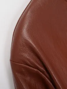 Vue détaillée montrant la texture grainée d'un ensemble veste en similicuir marron