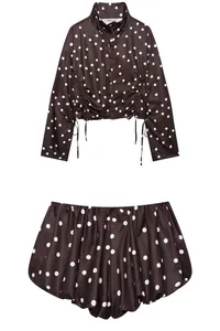 Detalle de conjunto de top de cuello alto y pantalones cortos de lunares marrones con cordón