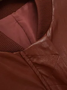 Détail en gros plan d'un col de veste en cuir marron avec texture maille côtelée