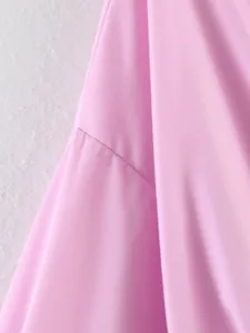Primo piano che mostra le cuciture di alta qualità e la trama di una camicia rosa a maniche lunghe