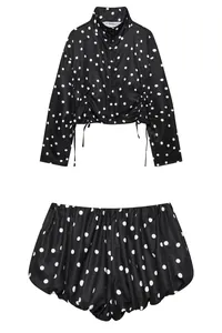Vista detallada de un conjunto elegante de lunares negros y blancos con top y shorts.