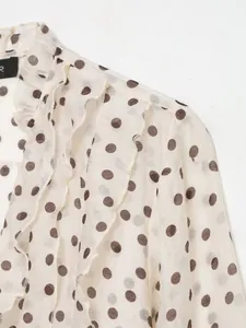 Gedetailleerde close-up van de ruches en het polkadots-patroon op de chiffon blouse