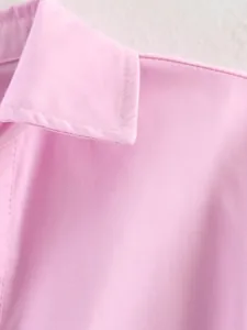 Dettaglio macro delle cuciture e del colletto di una polo rosa a maniche lunghe