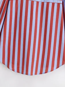 Detalle del dobladillo curvo de una camisa de verano con rayas verticales rojas y azules
