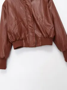 Gros plan de veste en simili cuir marron avec ourlet côtelé et poches en diagonale.