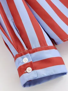 Primer plano del puño de una camisa de rayas elegante con dos botones blancos y dibujo