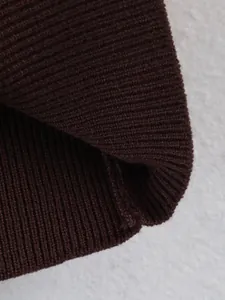 Close-up of dark brown ribbed knit sweater detail showing texture and material quality.