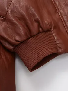 Détail de veste en cuir marron avec poignet élastique côtelé pour manteau femme