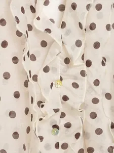 Close-up van polkadotstof met elegante ruches en glinsterende knoopjes details