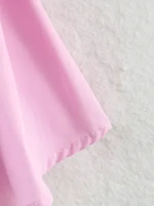 Dettaglio ravvicinato del tessuto rosa e delle cuciture curate di questo top da donna.