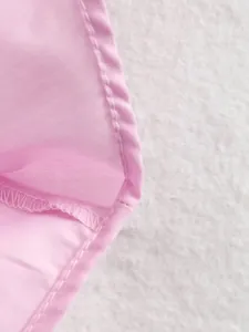 Macro dettaglio che mostra le cuciture pulite e il morbido tessuto rosa dell'abito polo.