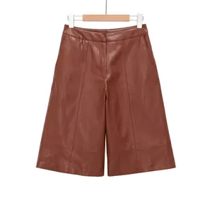 Vue de face d'un short large en similicuir marron à taille haute sur un cintre en bois