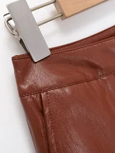 Gros plan sur la texture du similicuir marron et coutures fines de ce short taille haute