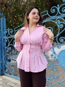 Camicetta rosa a maniche lunghe con colletto polo e vita a pieghe per uno stile chic.