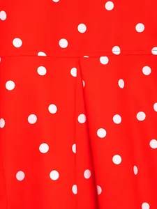 Primer plano de tela roja con lunares blancos, pliegues detallados y costuras finas