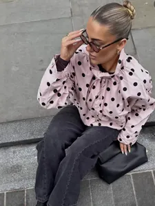 Chaqueta rosa con lunares, cuello alto y lazo para moda de primavera femenina con estilo.