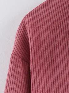 Detailweergave van de textuur en stiksels van een roze corduroy damesjas in detail