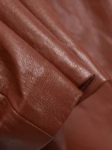 Gros plan détaillé de la texture du similicuir marron avec des coutures précises