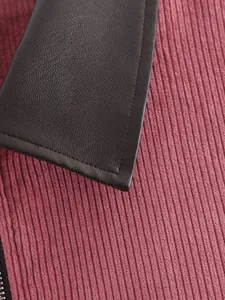 Macro-detail van roze corduroy stof en donkerbruine leren kraag met strakke stiksels