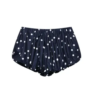 Vista detallada de los modernos pantalones cortos de burbuja azul marino con lunares blancos