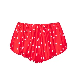 Vista detallada de los pantalones cortos rojos con lunares blancos y diseño plisado
