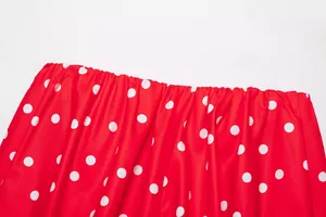 Vista detallada de la tela roja con lunares blancos y detalle fruncido elástico en la prenda