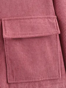 Detailopname van de roze corduroy textuur en klepzak op een casual damesjasje.